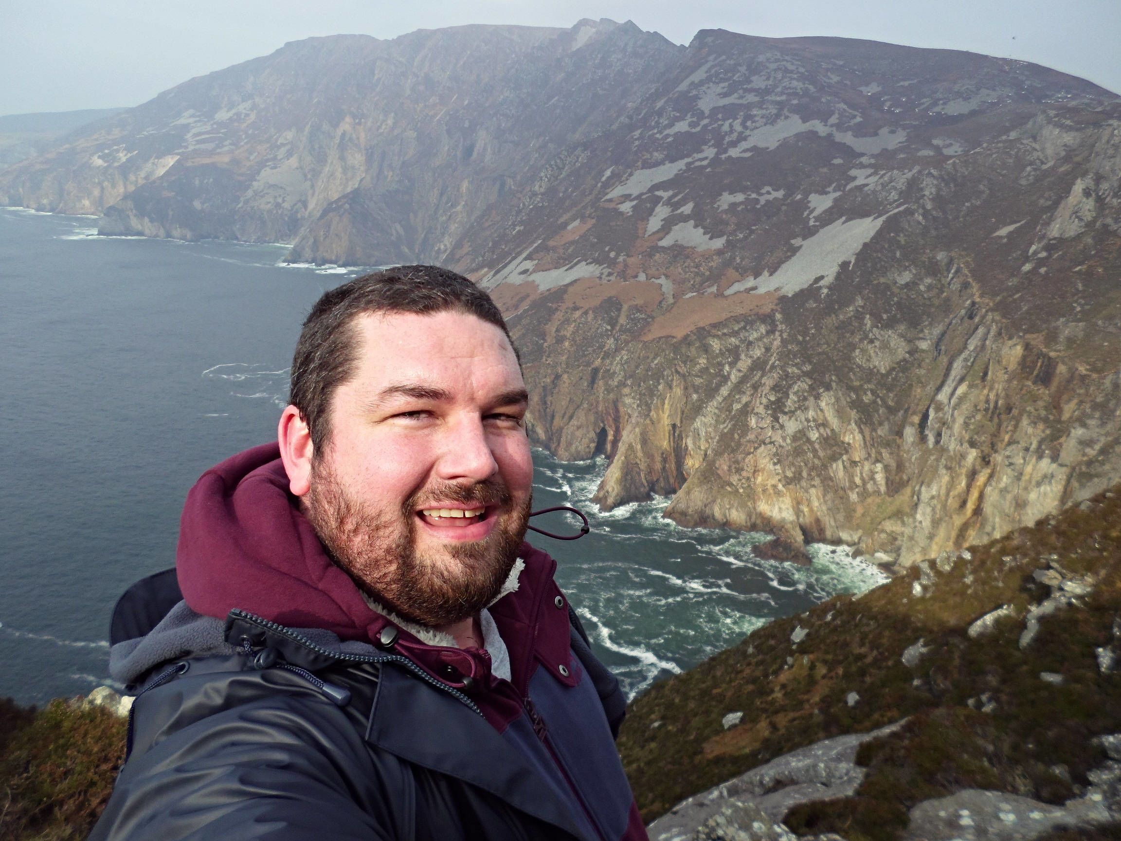 Daniel with the background of sea and mountains